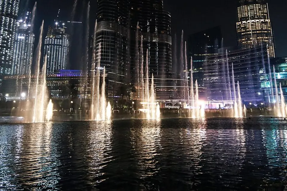 Dubai Fountain at night among illuminated Downtown towers